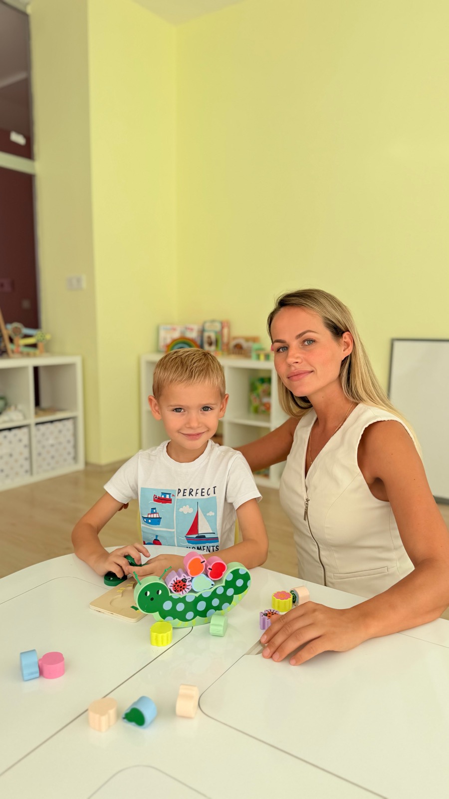 Педагог и ребёнок за столом с развивающей игрой